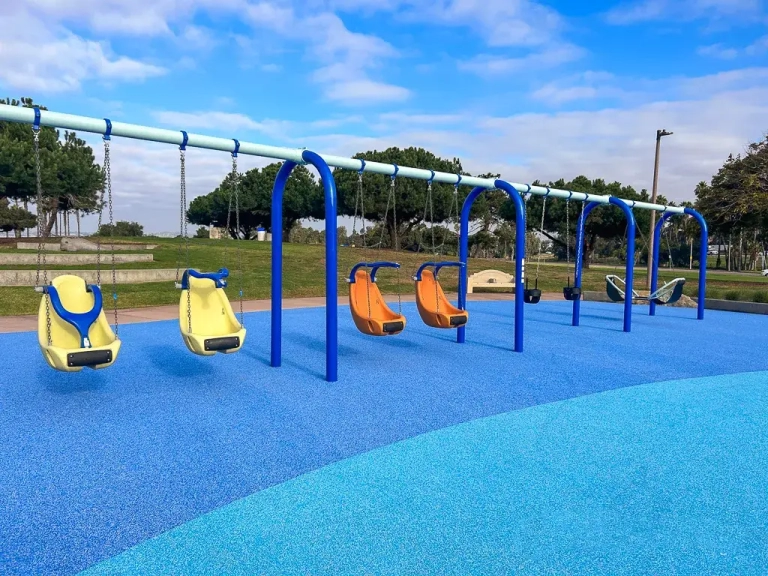 blue playground surfacing with orange swings